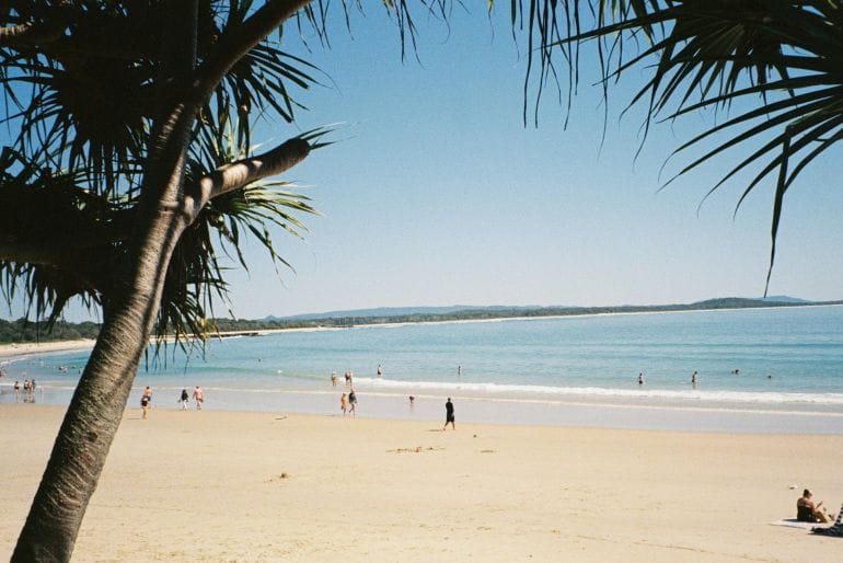 a group of people standing on top of a sandy beach