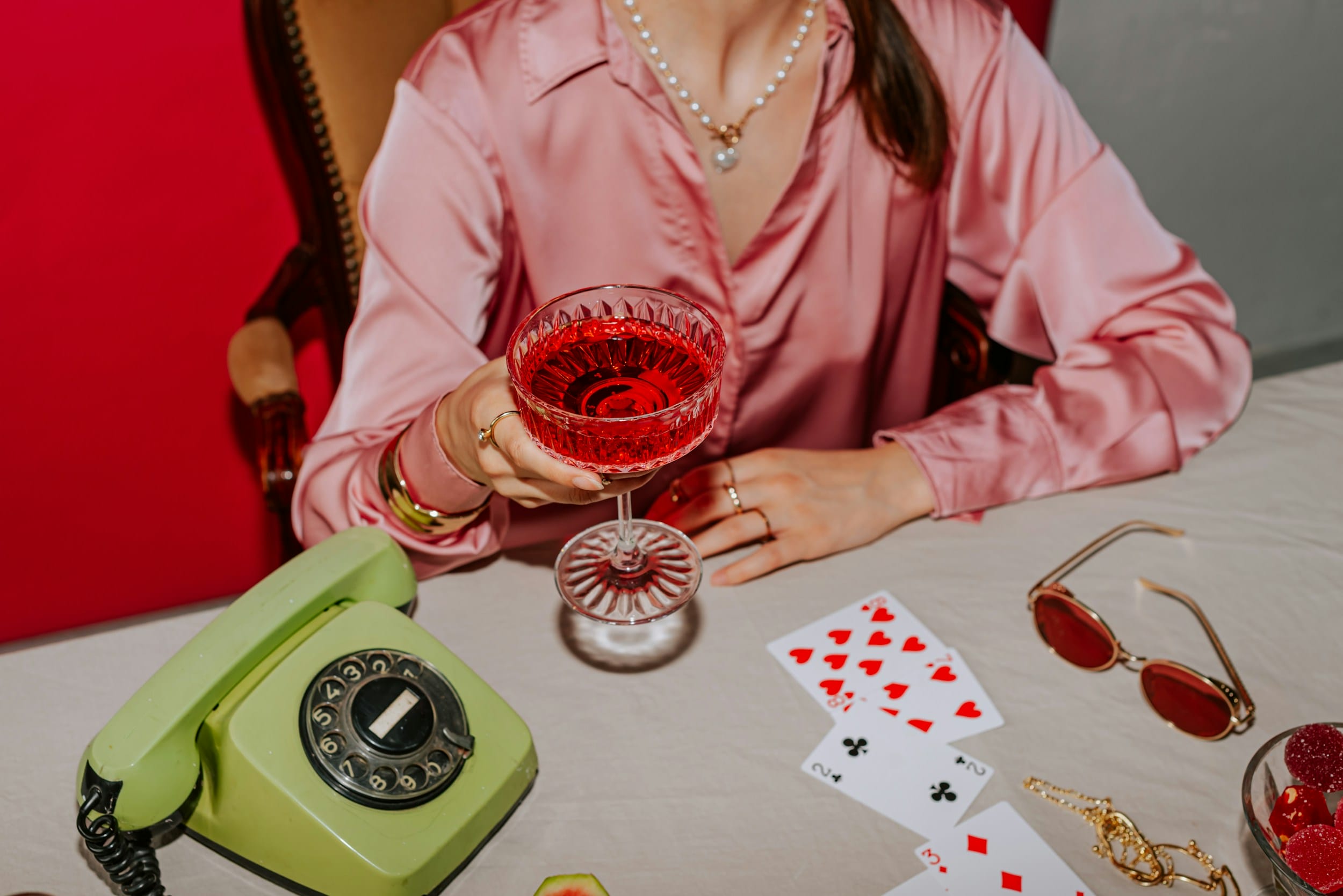 A woman sitting at a table holding a glass of wine