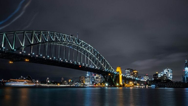 gray steel bridge over body of water during night time